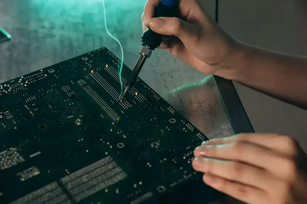Close up of a technician soldering a retro console motherboard